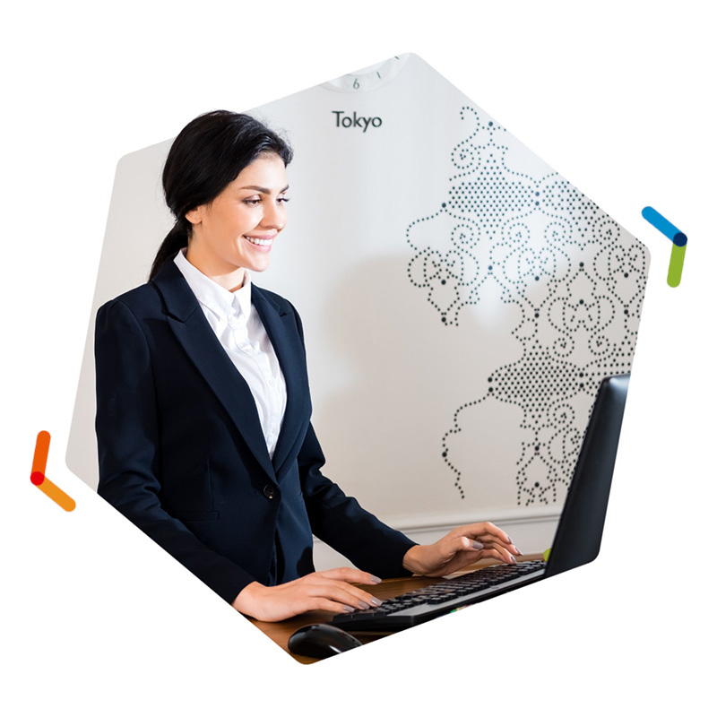 Woman standing behind desk using computer