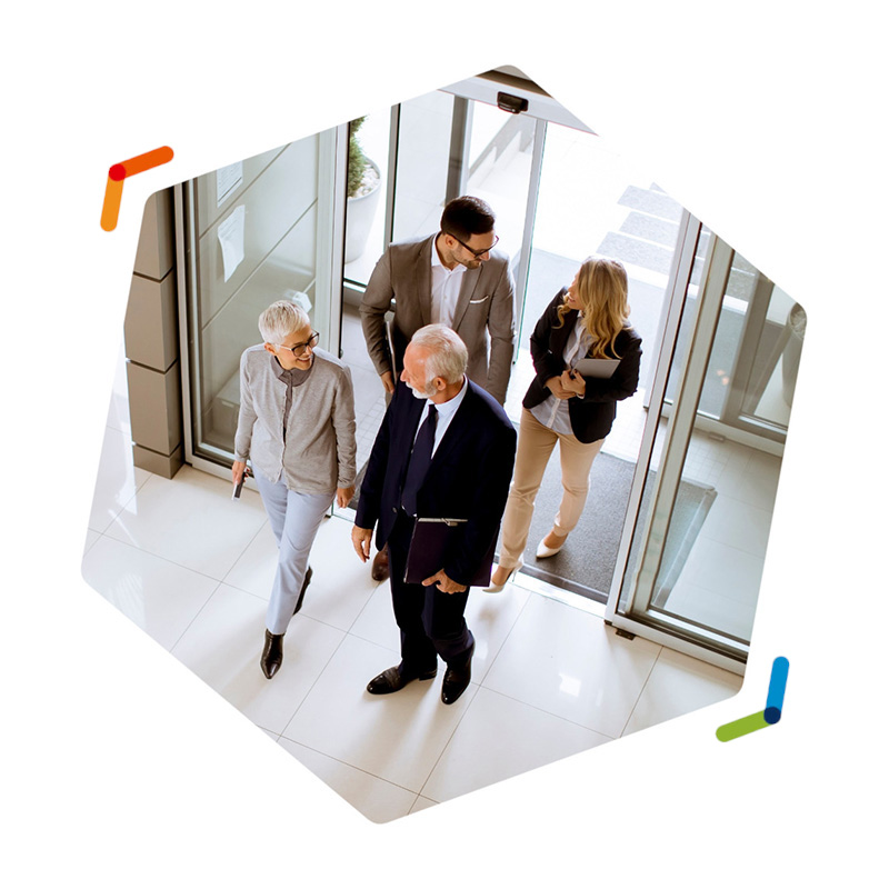 Group walking through glass door entrance of a building