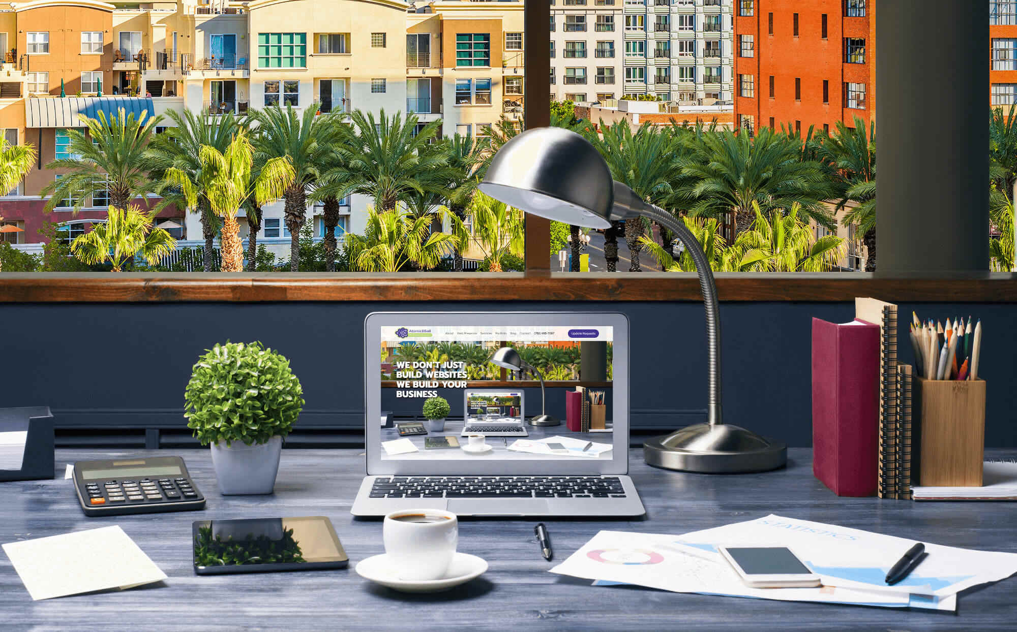 Laptop on a desk in front of a large window view