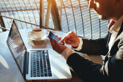 Business man using touchscreen on his cell phone.