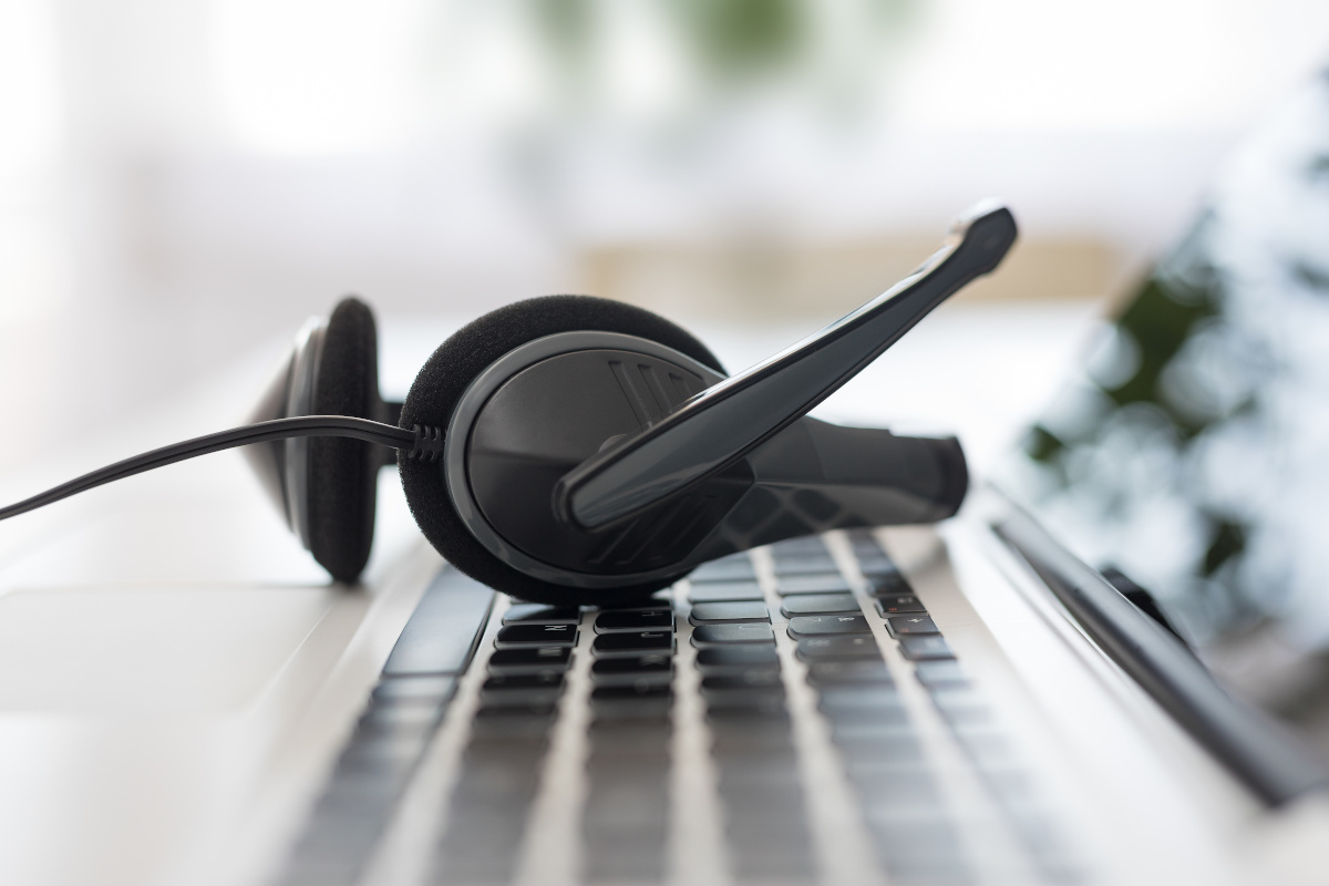 A headset rest on a laptops keyboard