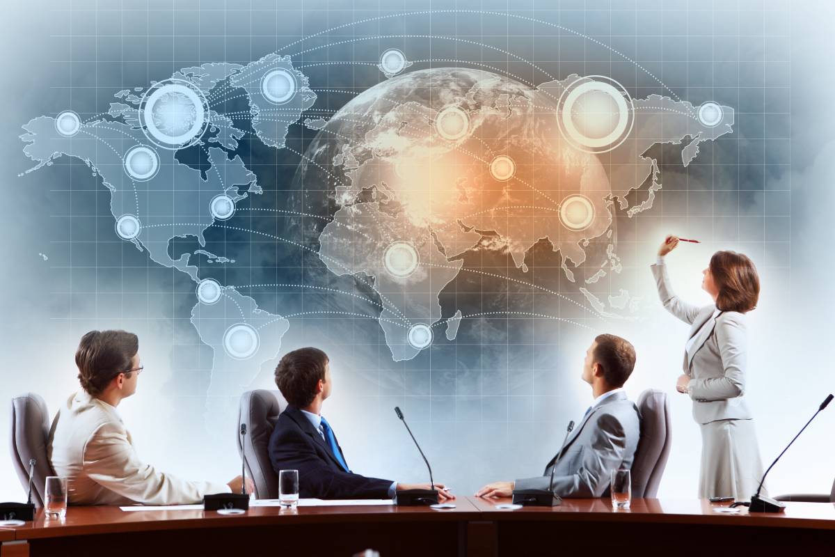 Four business people below composite of Earth with circles and lines connecting countries