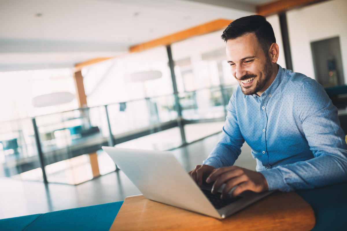 Smiling businessman working on laptop