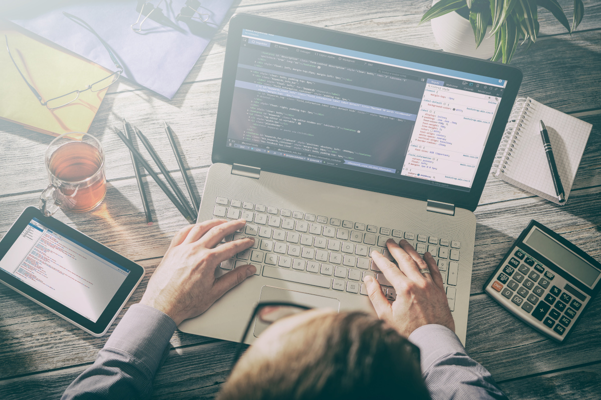 A laptop and tablet on a desk  displaying html inspections of a website